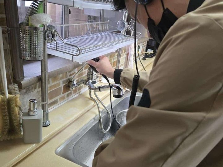 싱크대 하부 배관 누수 지점을 점검하는 기사