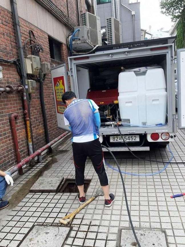 고압 호스로 맨홀을 세척하는 모습