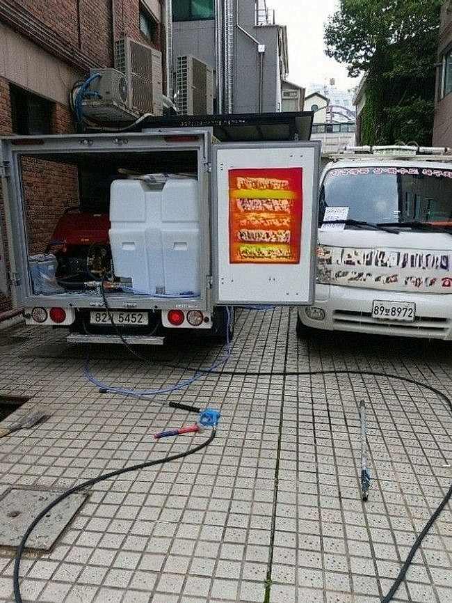 건물 앞에 댄 고압 세척 차량